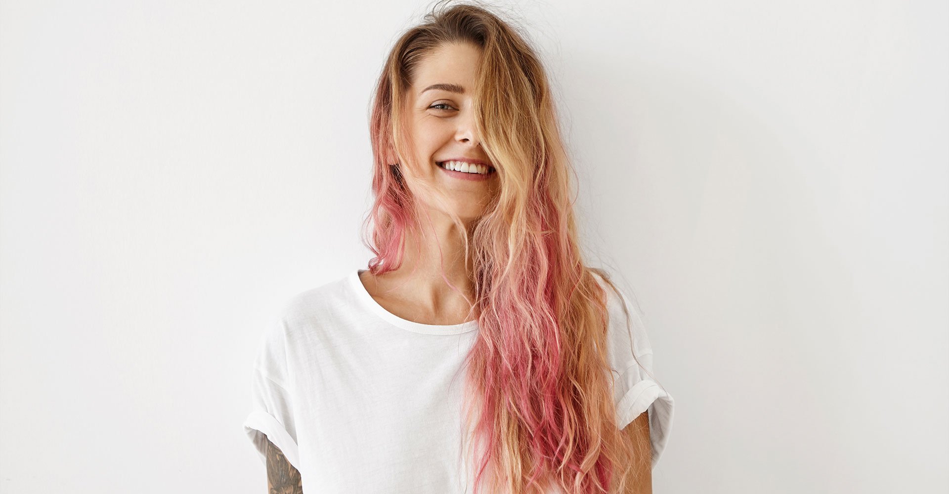 mulher branca de cabelo longo loiro com as pontas do cabelo rosa